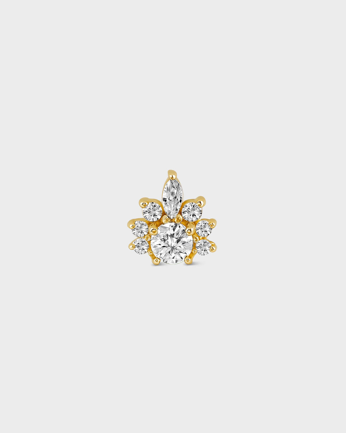 Gold earring with clear gemstones on a light gray background