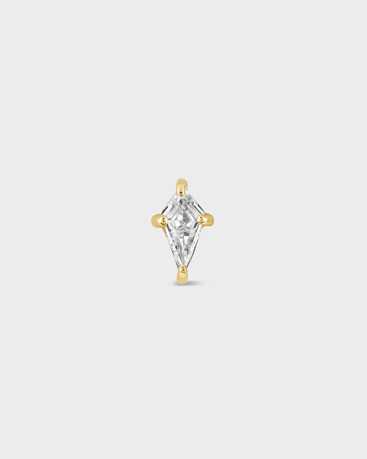 Gold and clear kite shape gemstone earring on a light gray background