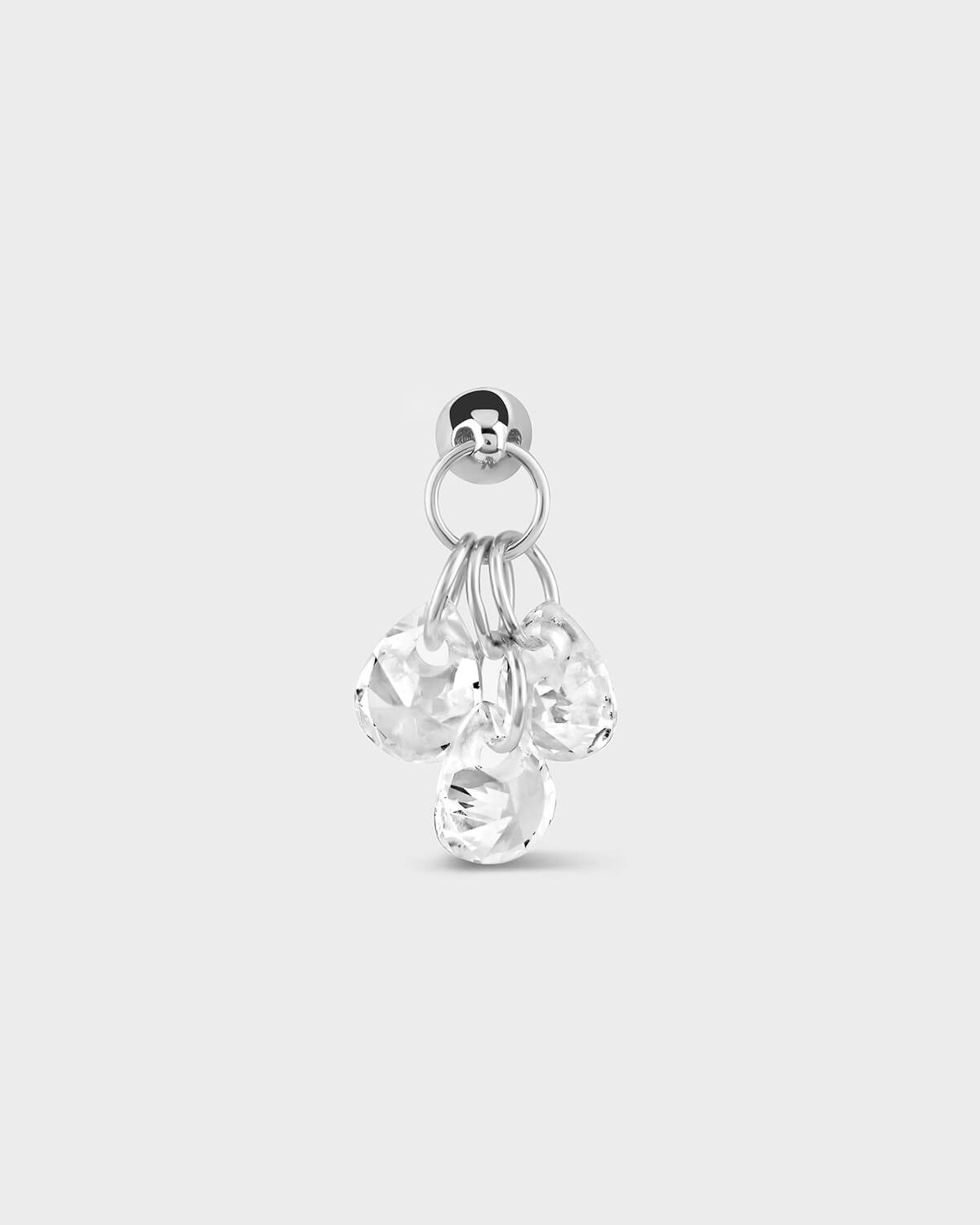 Silver earring with three dangling clear gemstones on a white background