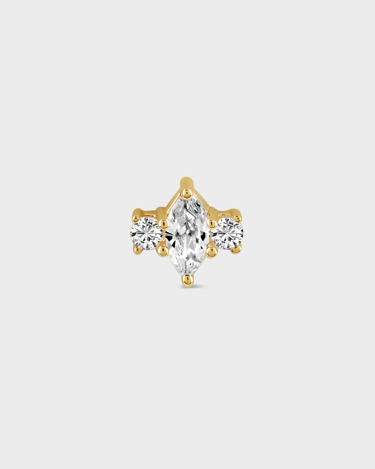 Gold earring with a central clear marquise gemstone and two round gems either side on a light gray background