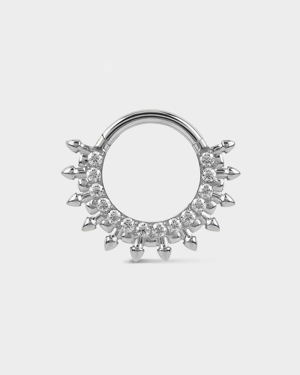 Polished titanium septum daith ring with diamond-like stones on a light gray background