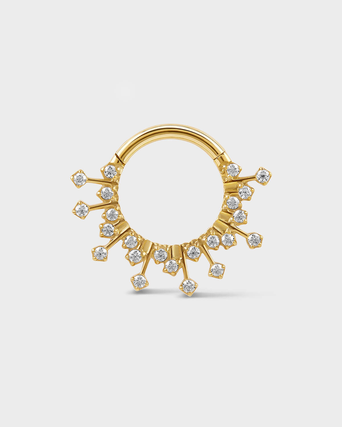 Gold titanium daith septum ring with small gramstones on a light gray background