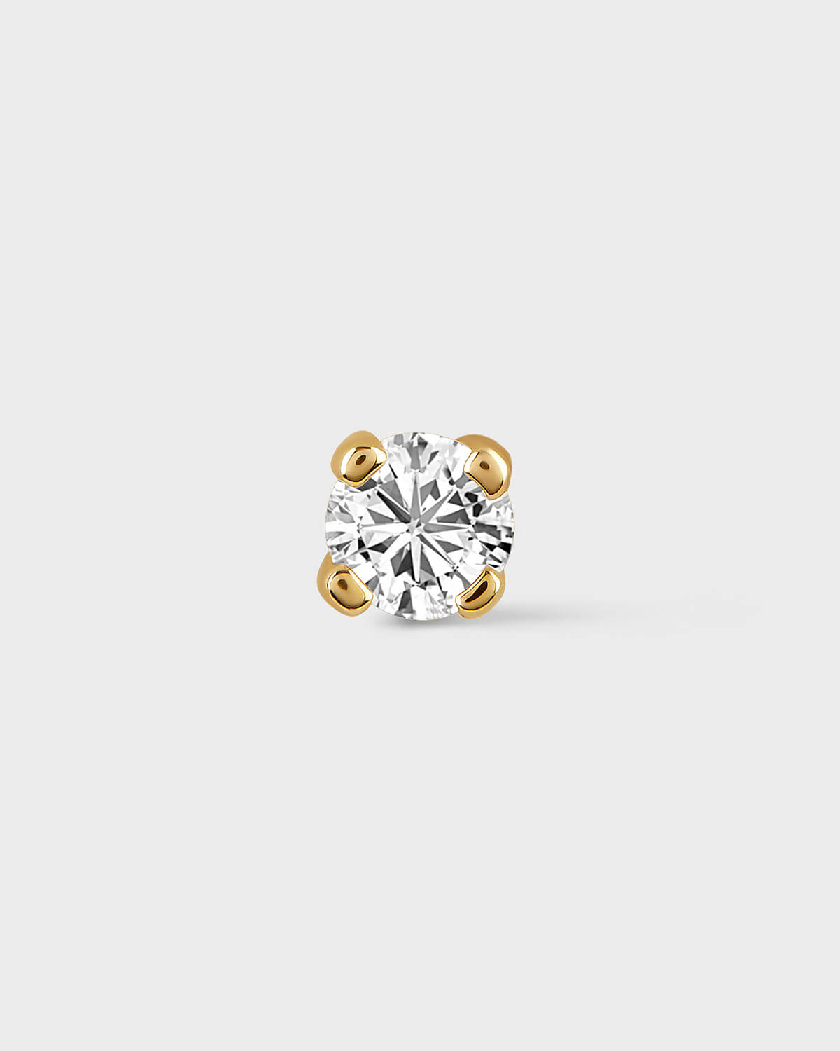 Single diamond earring on a light gray background
