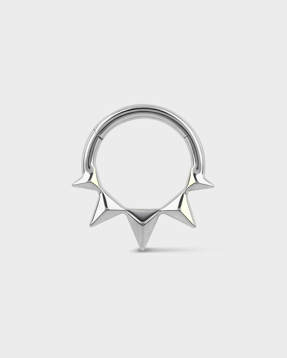 Silver septum ring with spike design on a white background