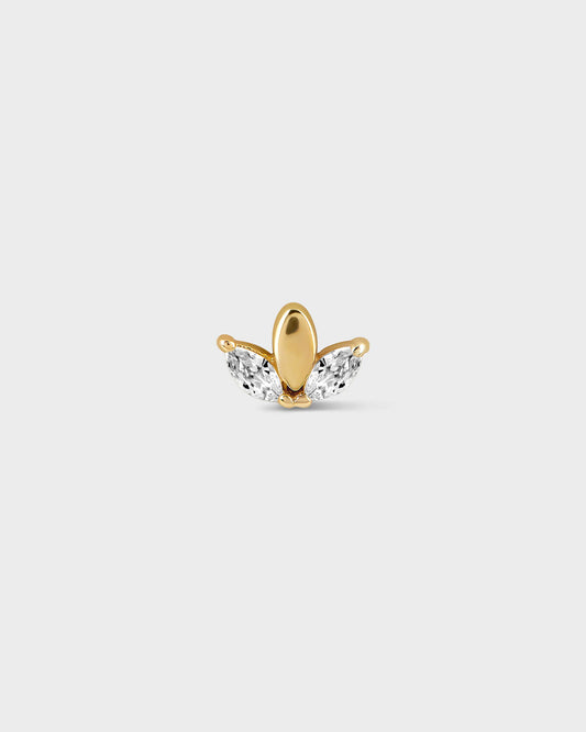 Gold and clear gemstone earring on a light gray background