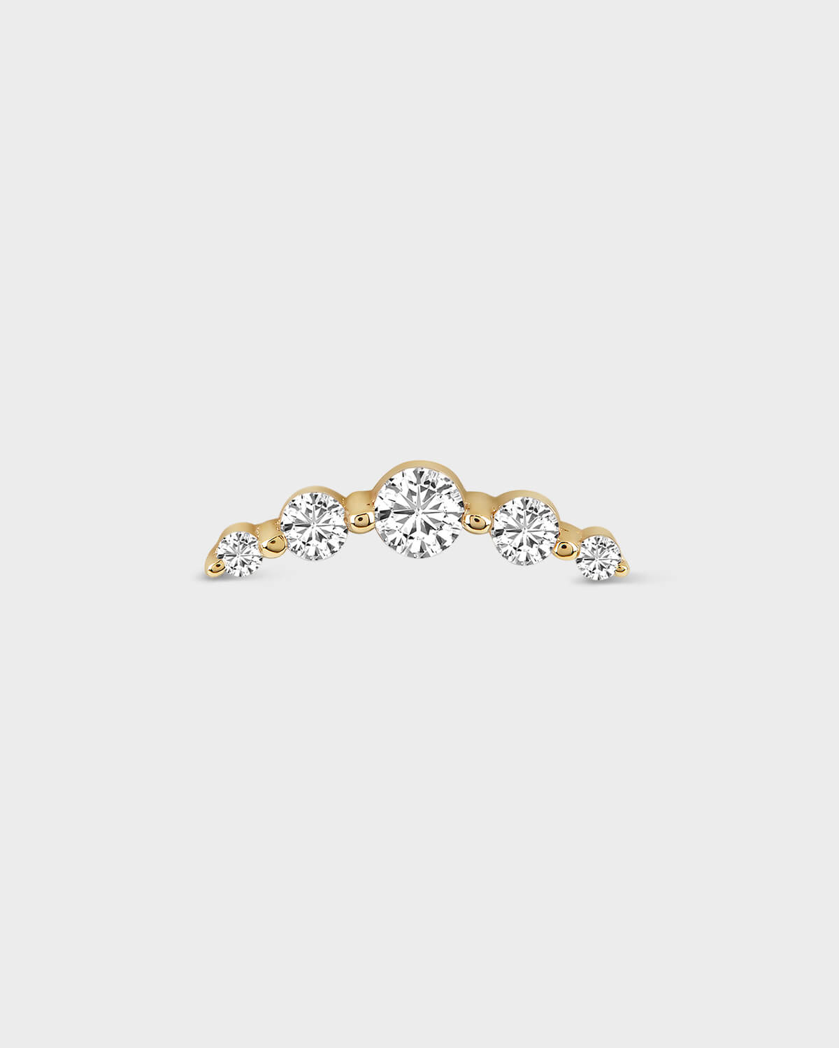 Gold earring with three clear gemstones on a light gray background