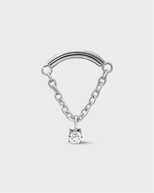 Polished silver titanium earring used for hidden helix or hidden rook featuring a smooth curved bar with a chain connected at each end and a single clear solitaire pendent on a light grey background.