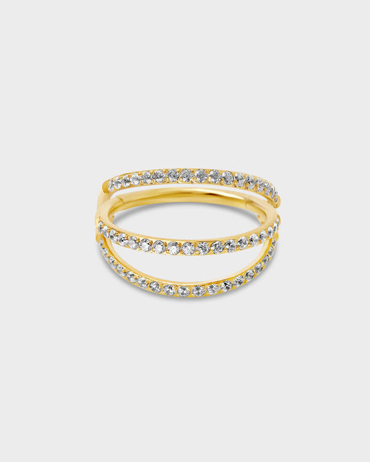 Gold titanium triple stack pave ring with clear gemstones on a light gray background.