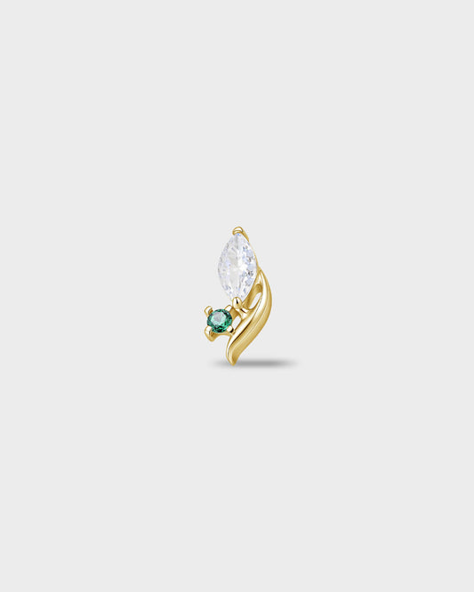 Gold titanium earring with a marquise-cut clear stone and a small round-cut emerald green stone set on a curved base, on a light gray background.