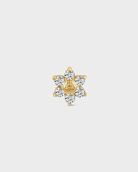 Gold and diamond earring on a light gray background