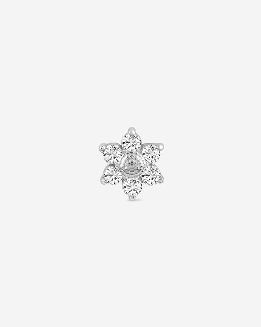 Silver flower-shaped earring on a light gray background