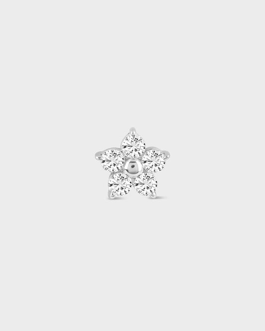 Flower shaped diamond earring on a light gray background