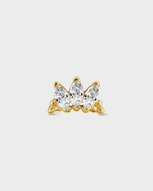 Gold earring with three clear gemstones on a light gray background