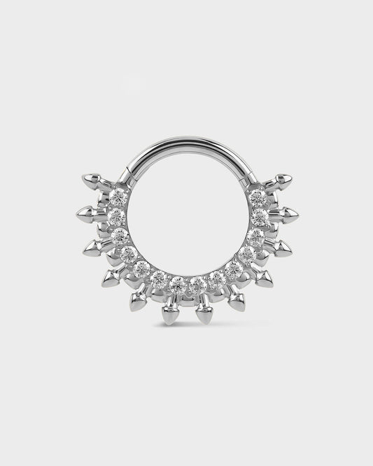 Polished titanium septum daith ring with diamond-like stones on a light gray background