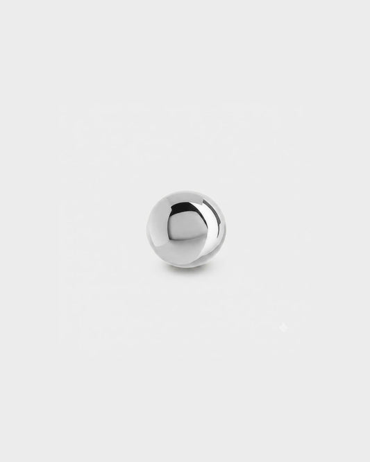 Plain polished silver titanium ball for piercing jewellery on a light grey background