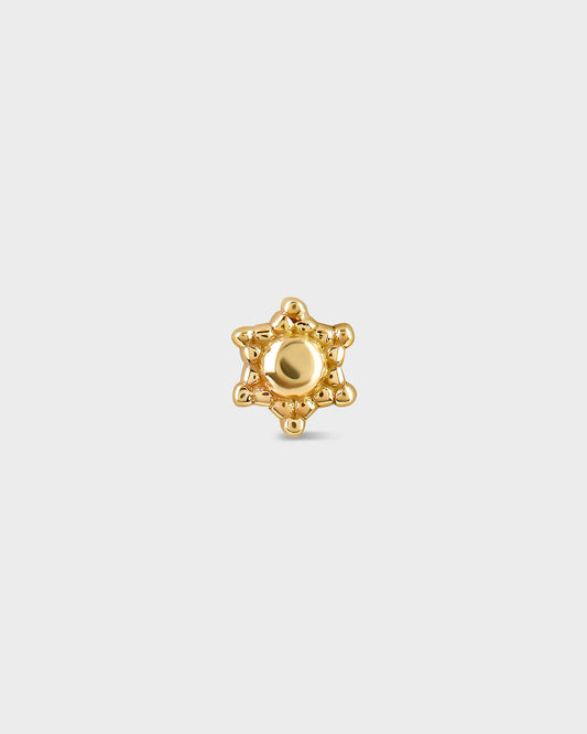 Gold star-shaped earring on a light gray background