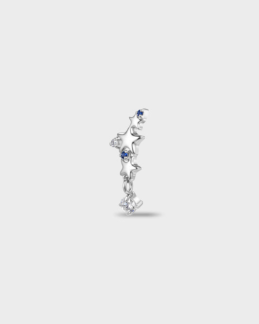 Polished titanium earring with a row of star shapes set with blue and clear round-cut stones, finished with a short dangle and a clear round-cut stone, on a light gray background.