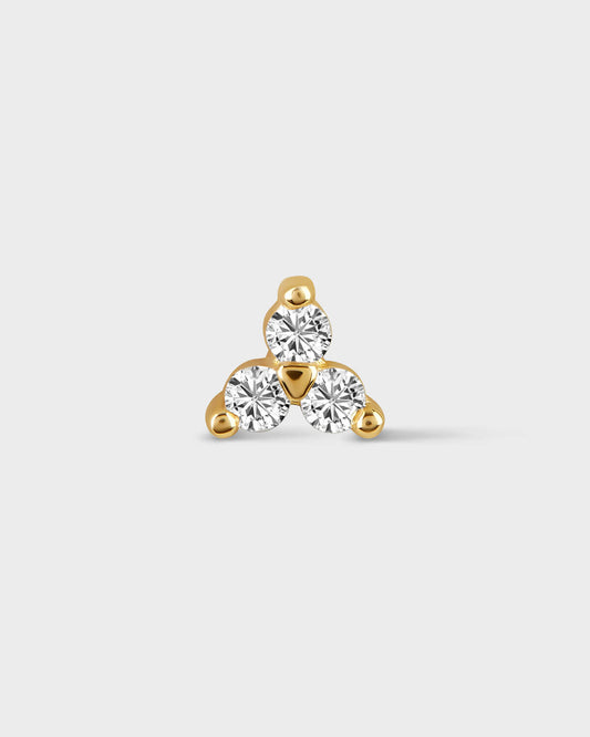 Gold earring with three clear gemstones on a light gray background