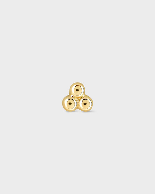 Gold triskele earring on a light gray background