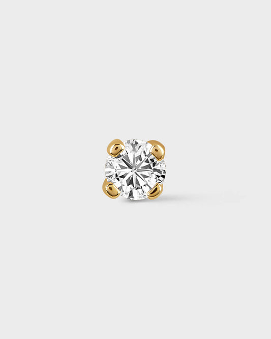 Single diamond earring on a light gray background