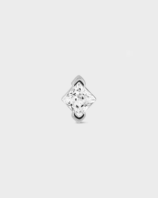 Single stud earring with a clear gemstone on a light gray background